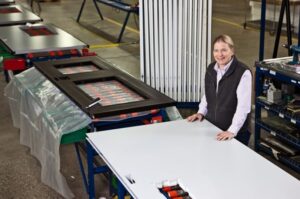 lady showcasing metal doors being manufactured